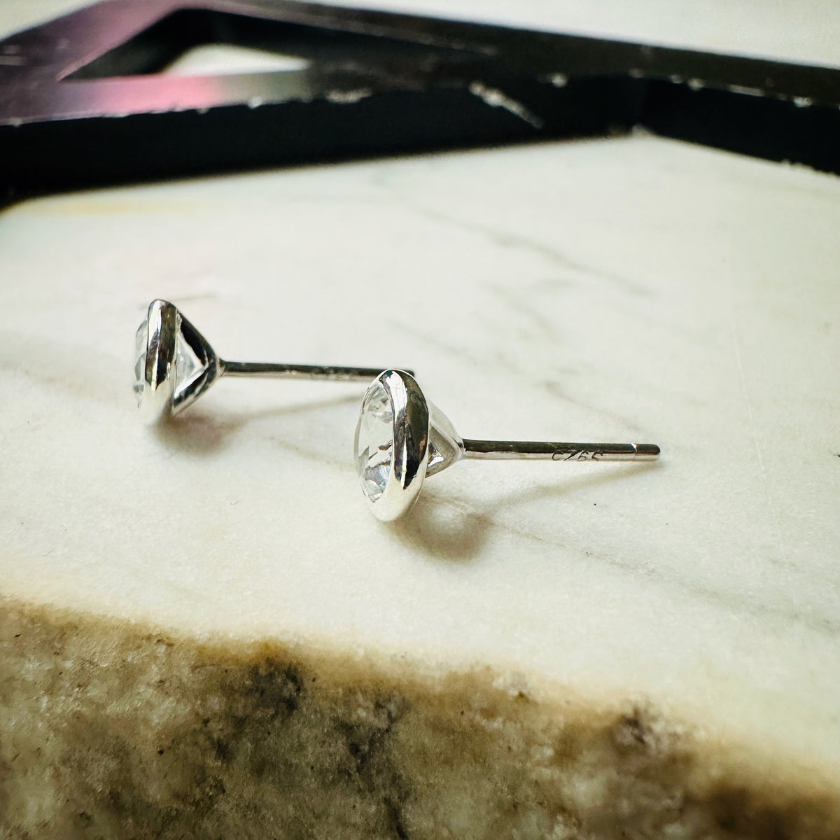 5mm white topaz bezel set stud earrings in sterling silver viewed from the side to show posts