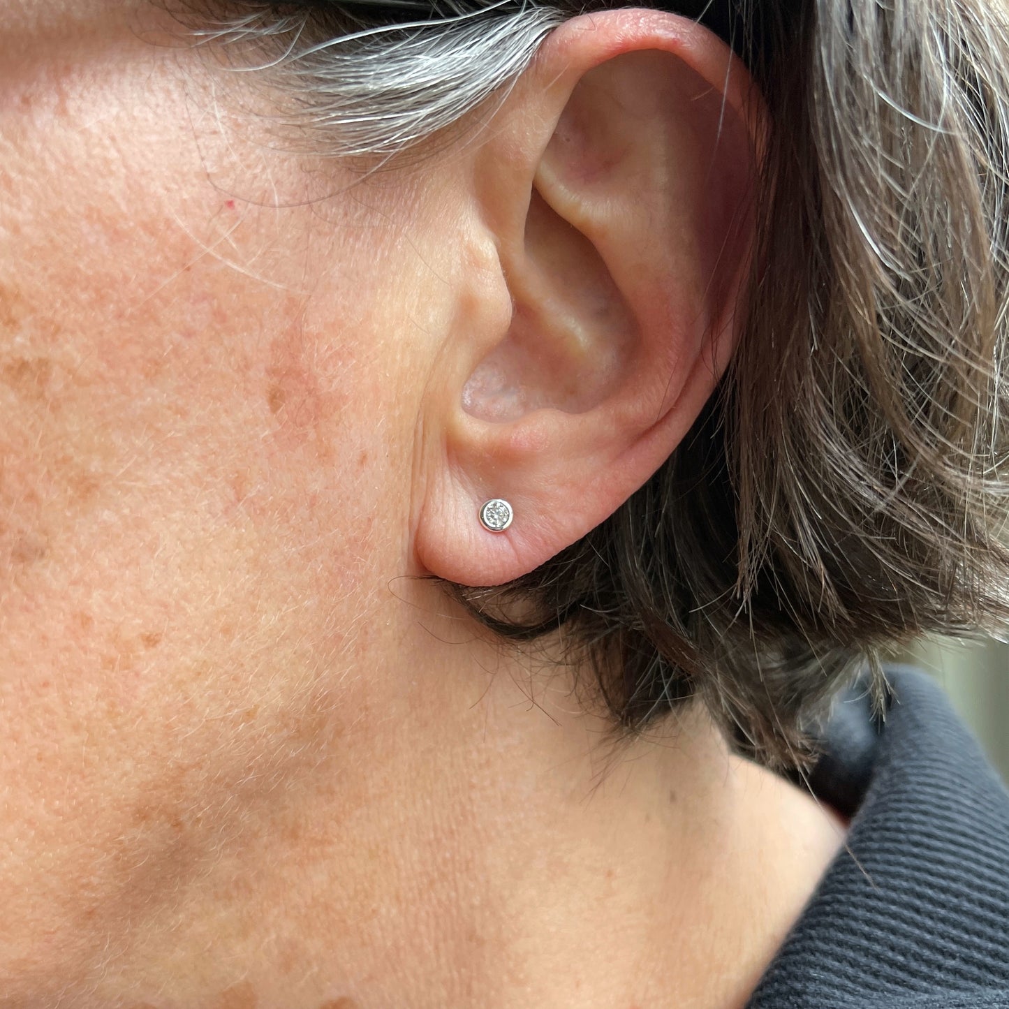 3mm moissanite studs shown worn on a model