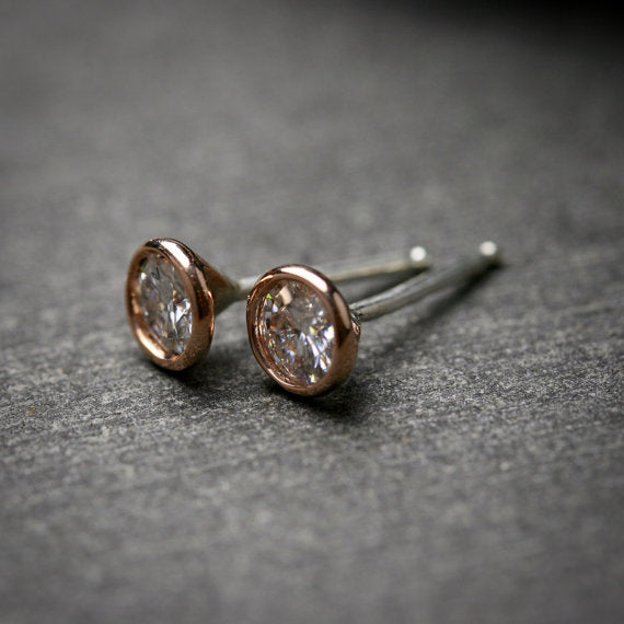 14k rose gold bezel set Moissanite stud earrings shown with sterling silver posts