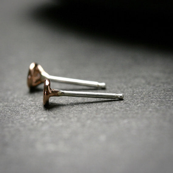 14k rose gold bezel set Moissanite stud earrings shown from the side with sterling silver posts