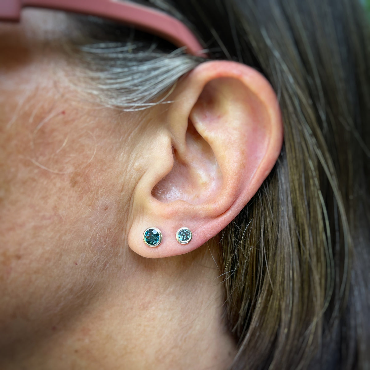 an ear with 4mm and 5mm London blue topaz studs. Showing scale