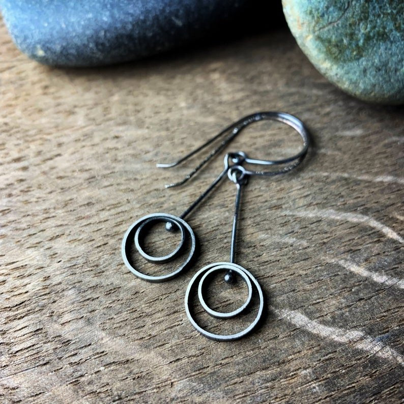 two earrings with concentric circles and ear wires. made of oxidized sterling silver.