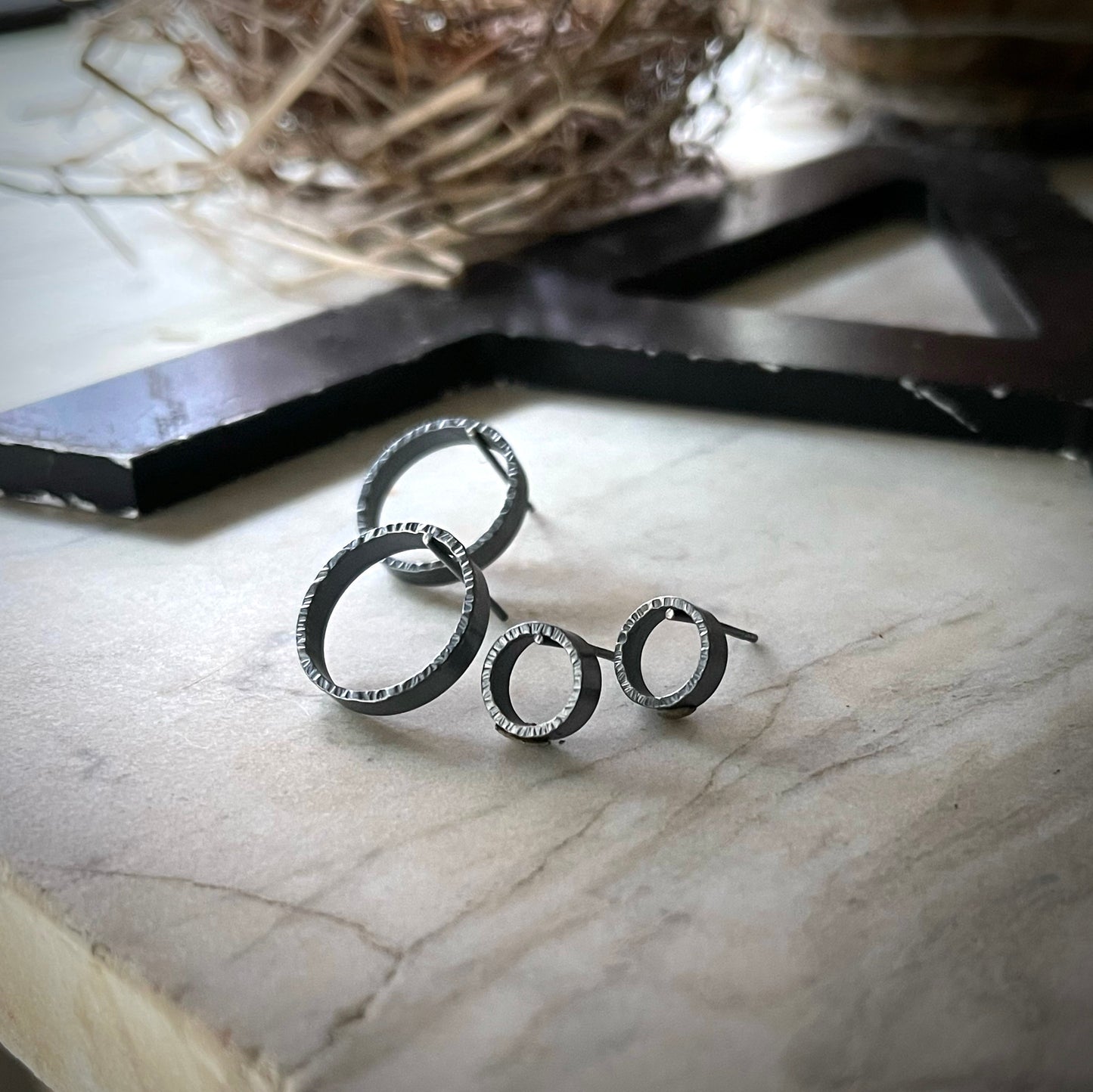 two pair of textured circle hoop earrings. one pair is large and the other small