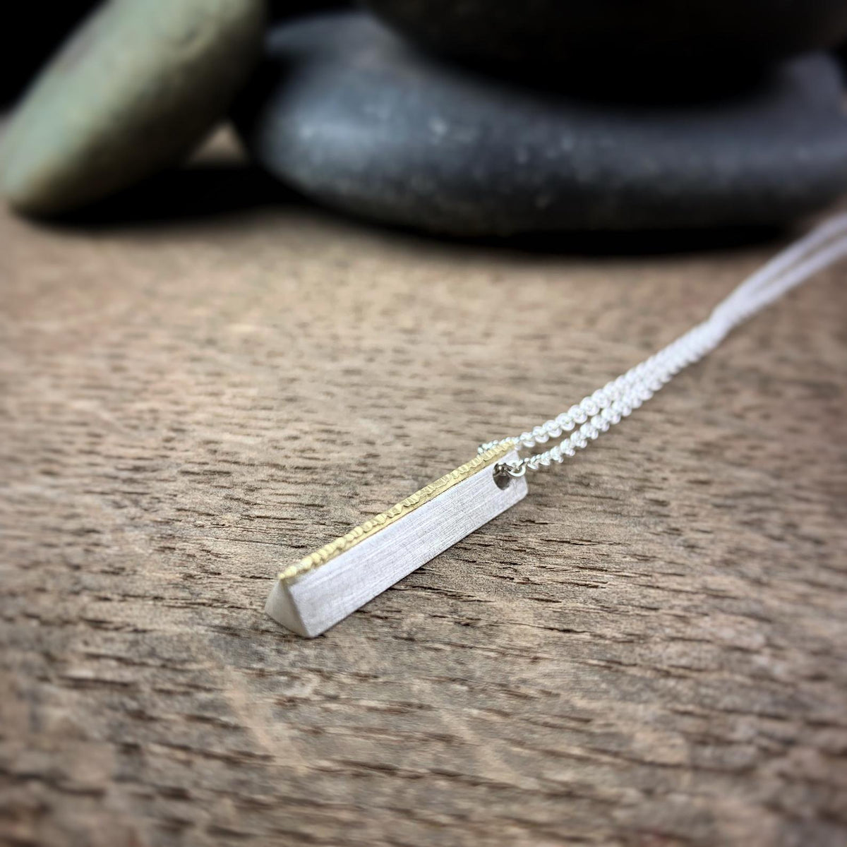 Minimal sterling silver bar pendant topped with hammered 18k yellow gold