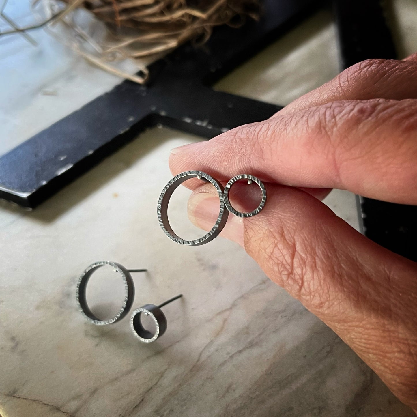 two pair of textured circle hoop earrings. One pair is large and the other is small.