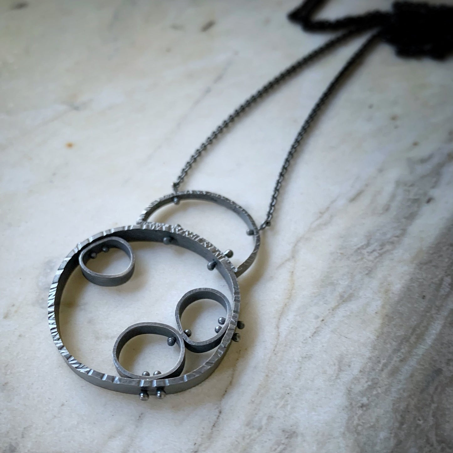modern circles connected to make an industrial looking sterling silver pendant