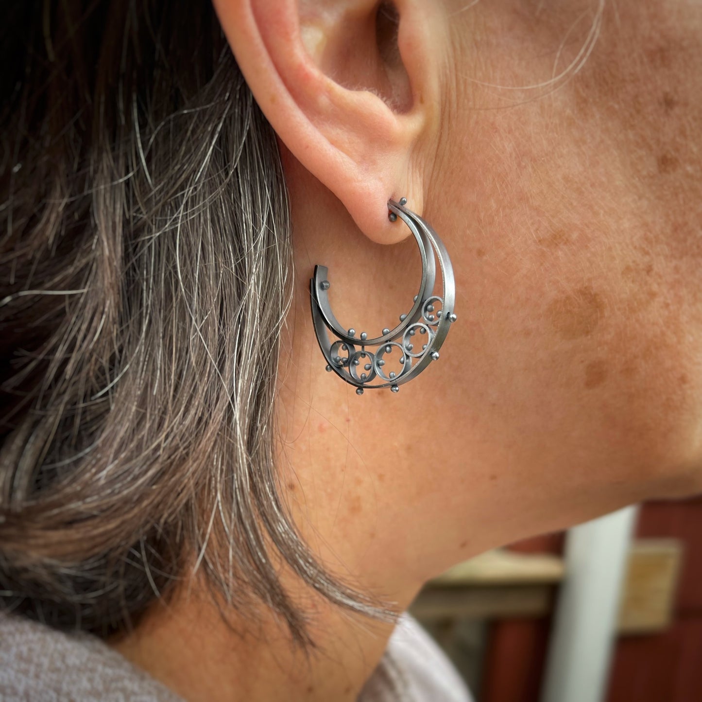 half moon shaped hoop earrings shown on a model