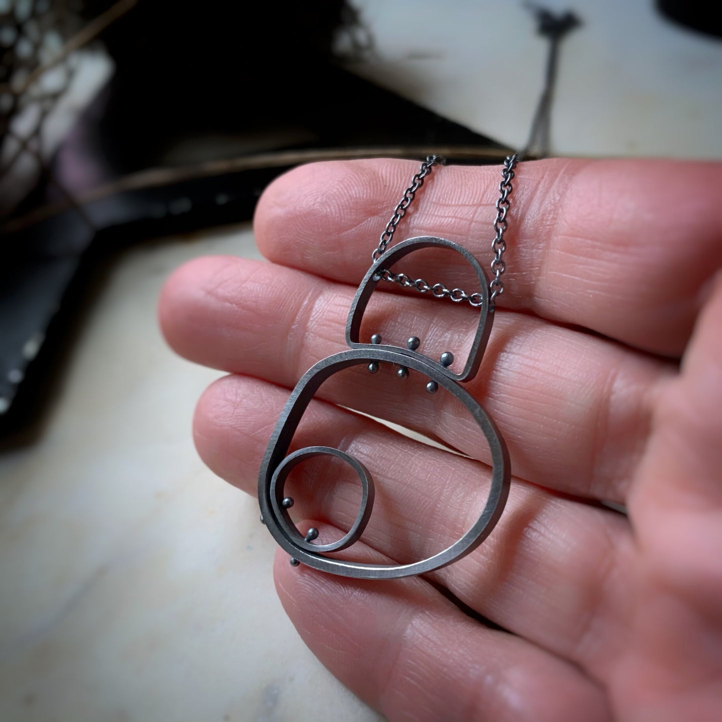 Circle in circle with a half circle bail pendant in darkened silver