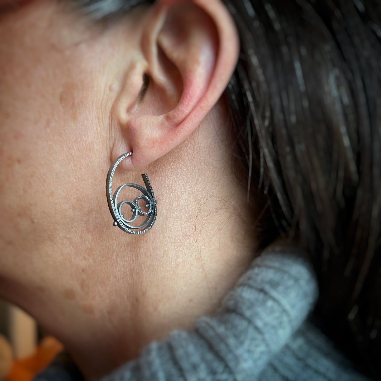 oxidized sterling silver circle hoops shown being worn for scale