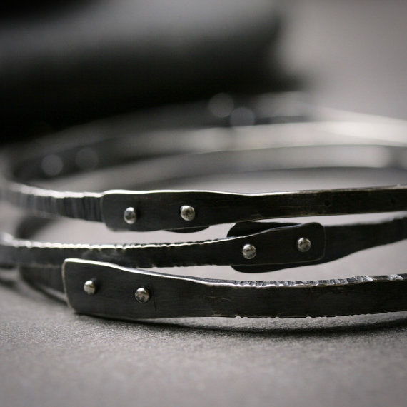 detail of silver rivets on oxidized bangle bracelets