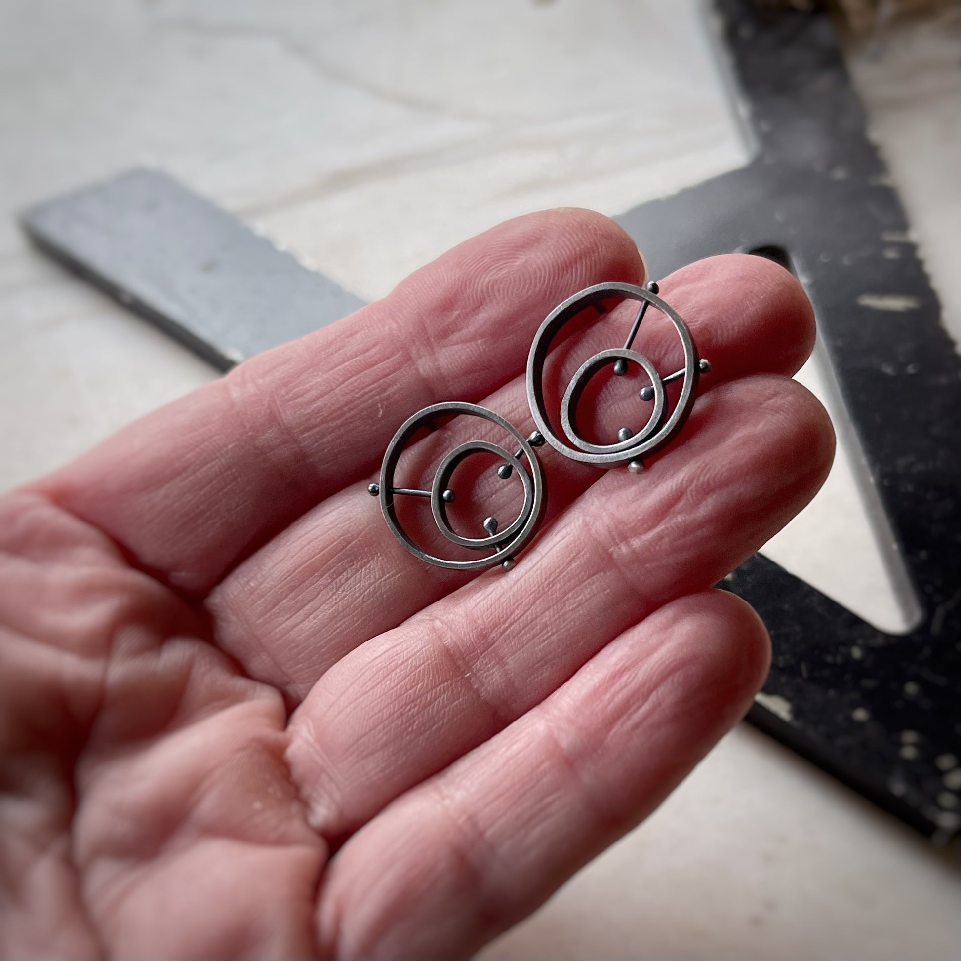 the earrings on a hand showing scale.