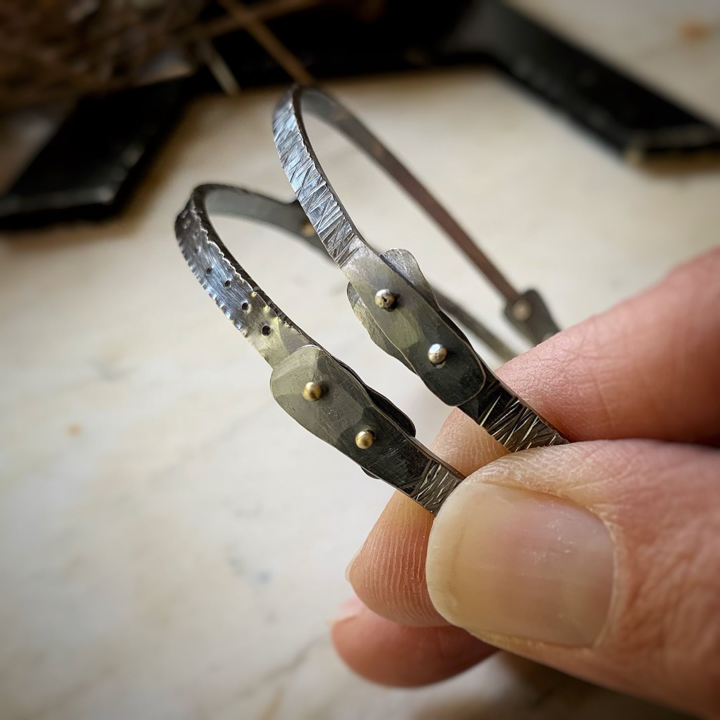 Two oxidized sterling silver bangle bracelets with silver an gold rivets.