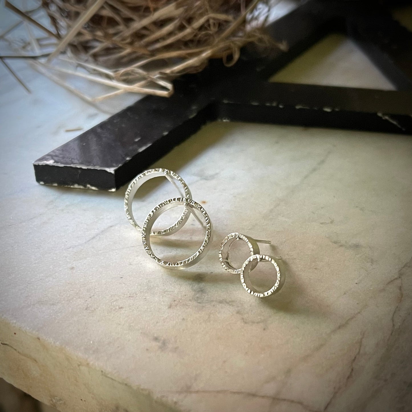 two pair of textured circle hoop earrings. one pair is large and the other small