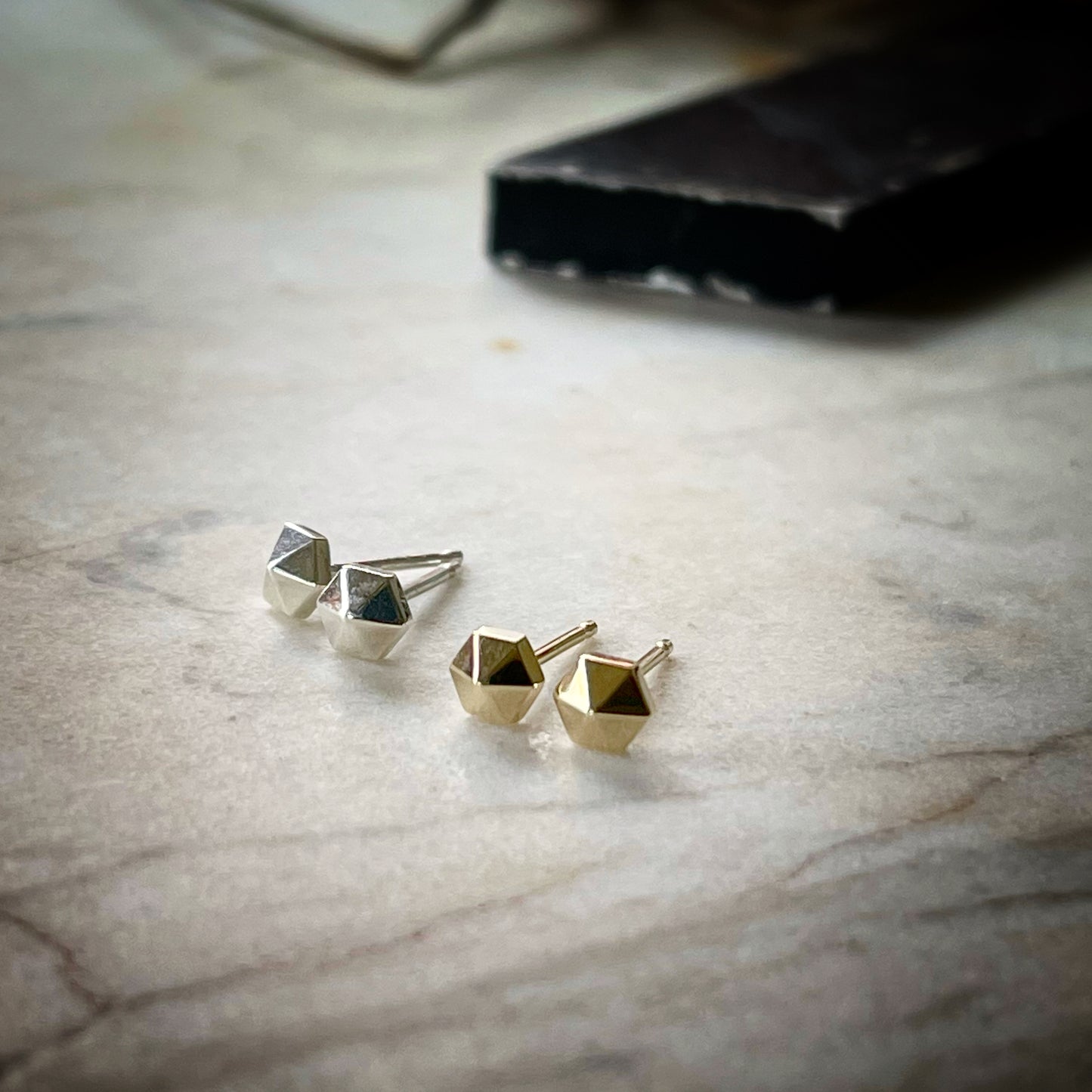 tiny hexagonal stud earrings. A pair in sterling silver and a pair in 14k yellow gold