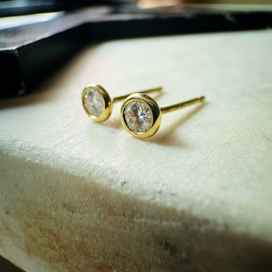 18k yellow gold 3mm Moissanite bezel set stud earrings on a marble background 