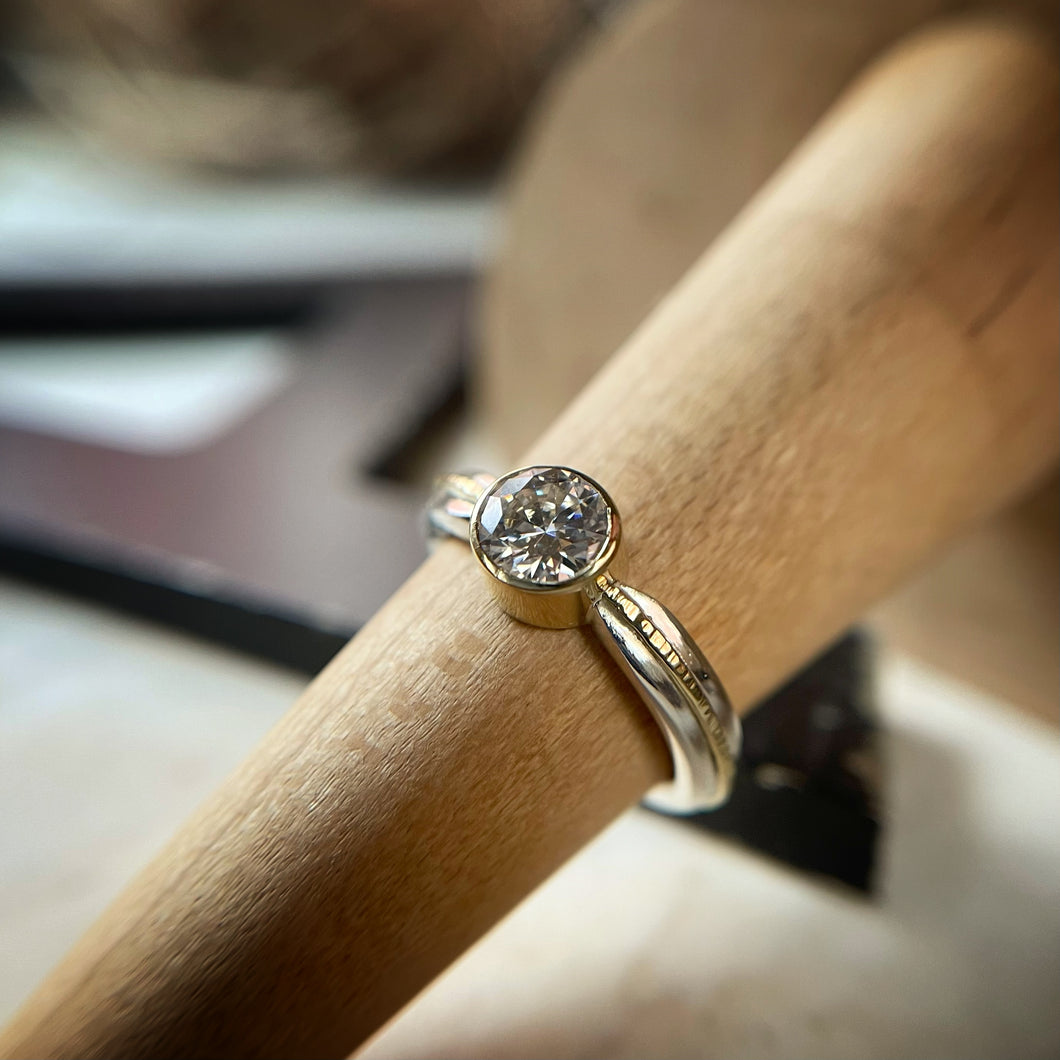 6mm moissanite set in an 18k yellow gold and sterling silver ring.  