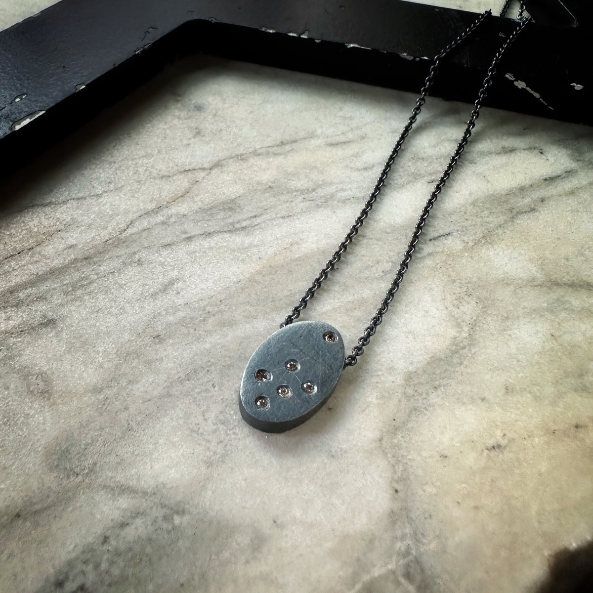 Oxidized sterling silver pendant scattered with tiny cognac diamonds