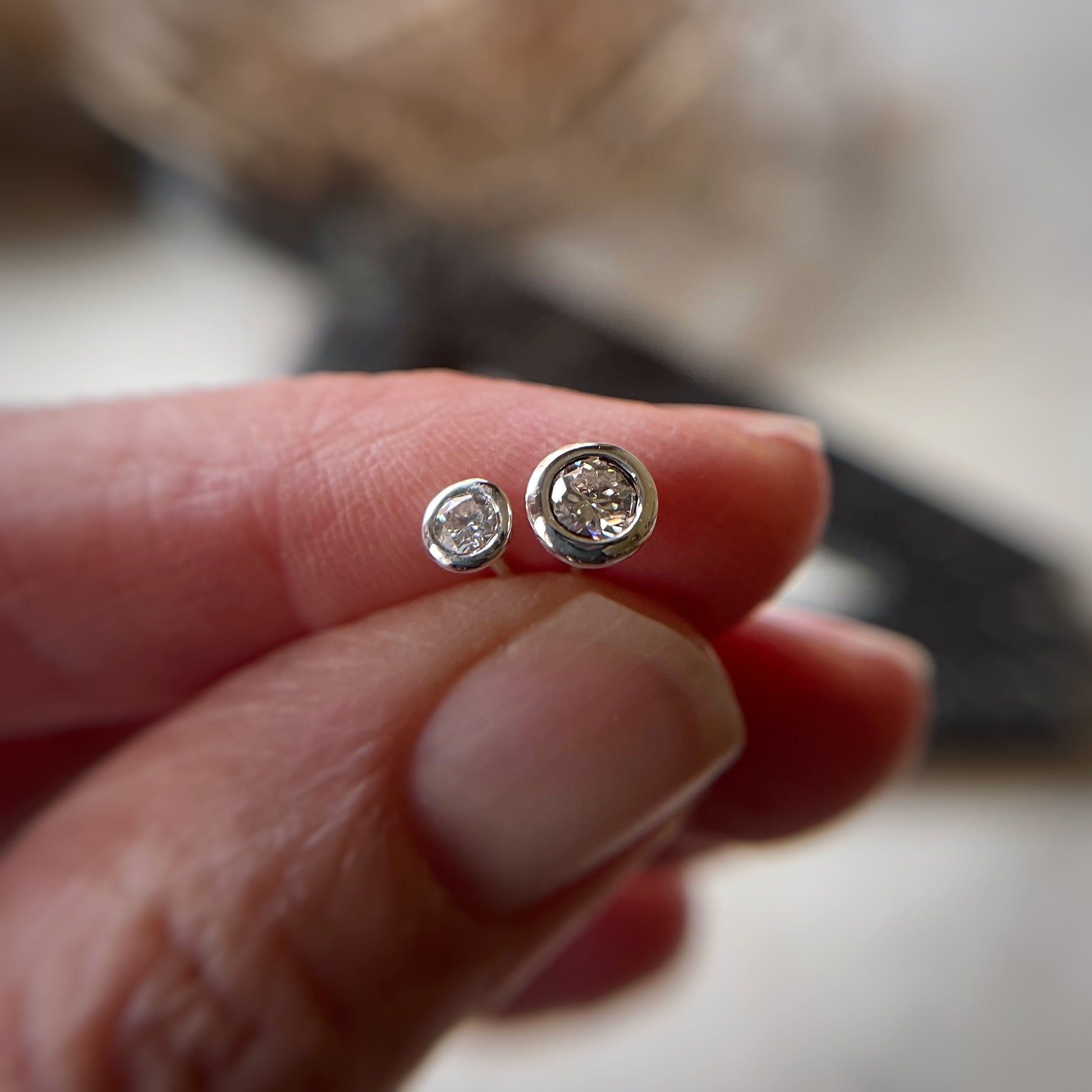 a size comparison between 3mm and 4mm bezel set moissanite stud earrings