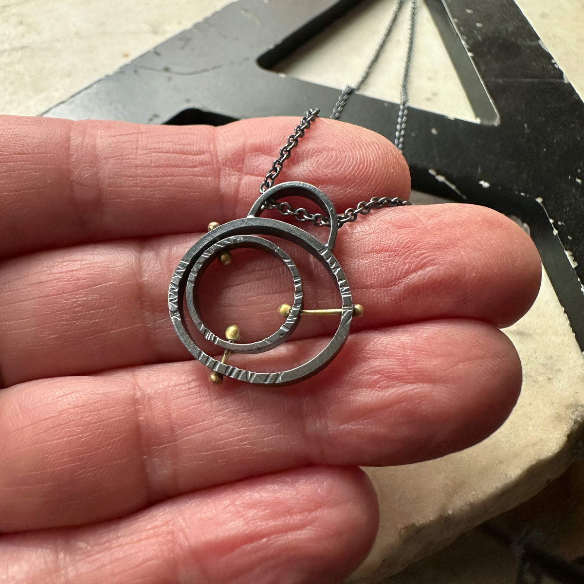 Mid-century atomic pendant in oxidized sterling silver with concentric pin detail