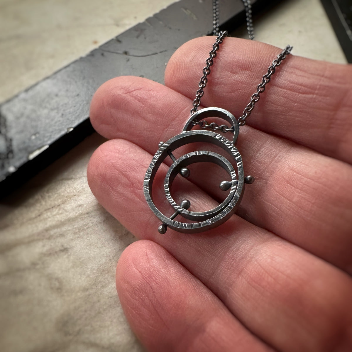 Mid-century atomic pendant in oxidized sterling silver with concentric pin detail