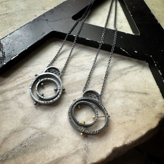 Mid-century atomic pendant in oxidized sterling silver with concentric pin detail