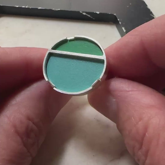 a sterling silver oval topped ring with a green formica top and blue formica bottom 