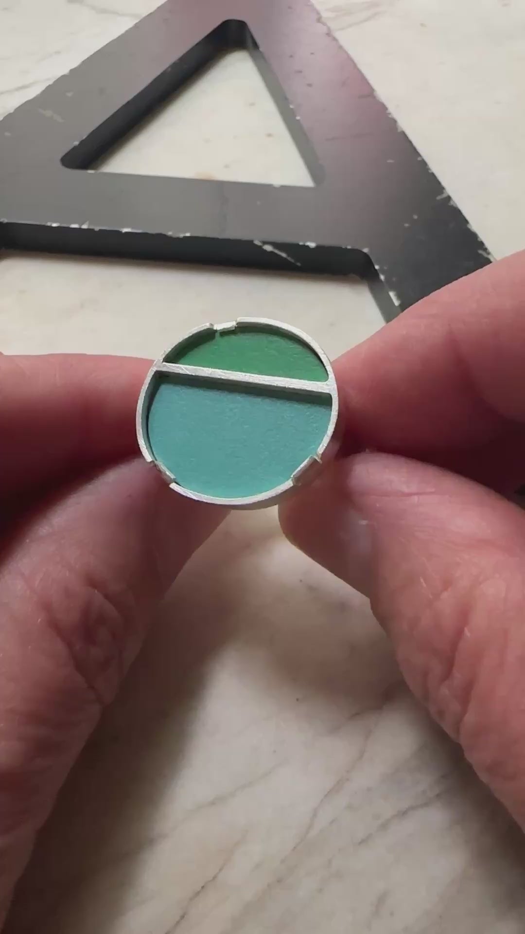 a sterling silver oval topped ring with a green formica top and blue formica bottom 