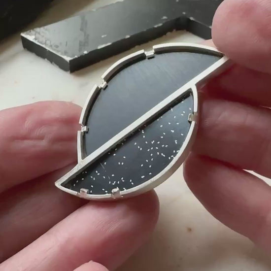 A geometric brooch with two types of black formica set in sterling silver 