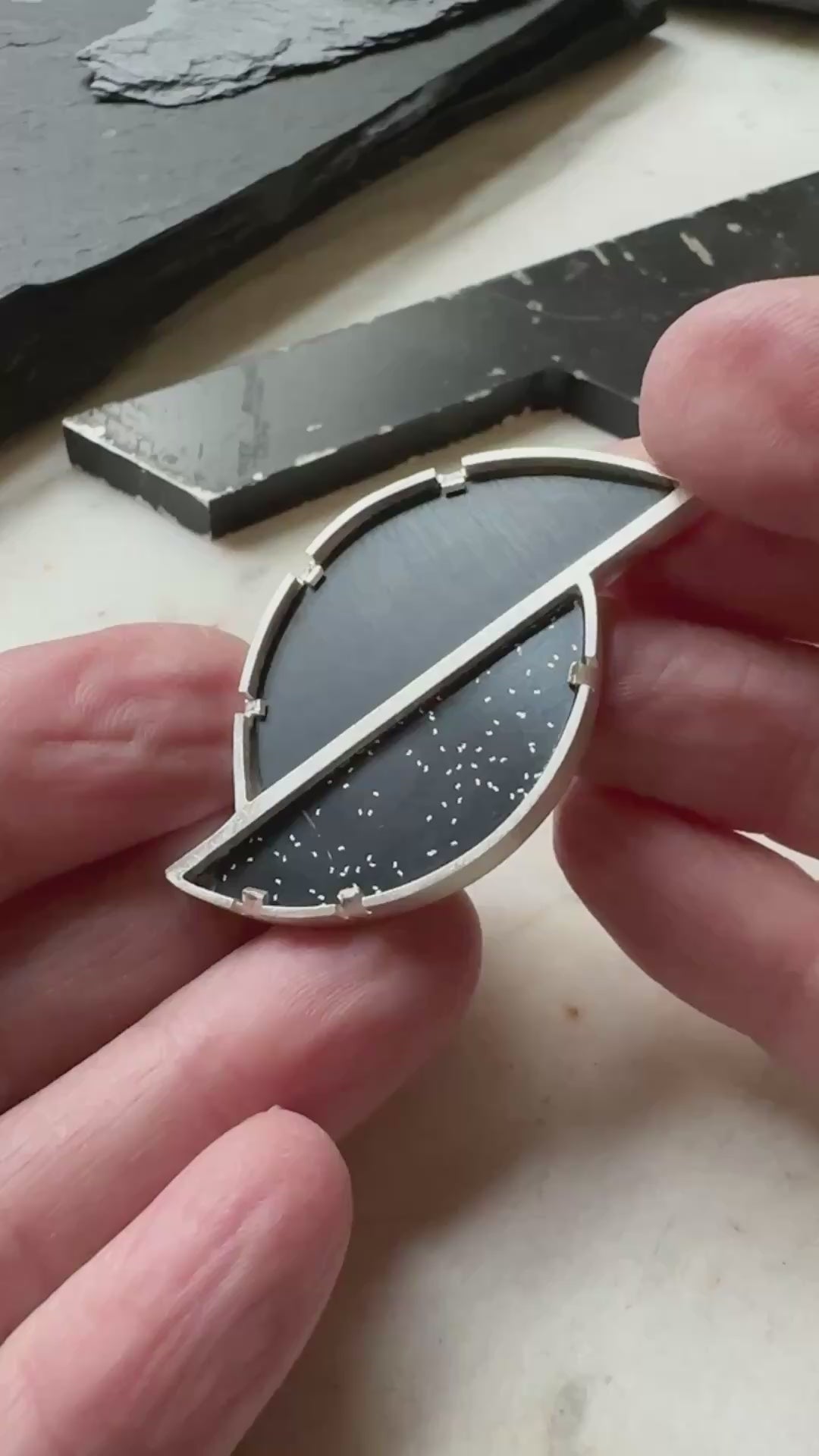 A geometric brooch with two types of black formica set in sterling silver 