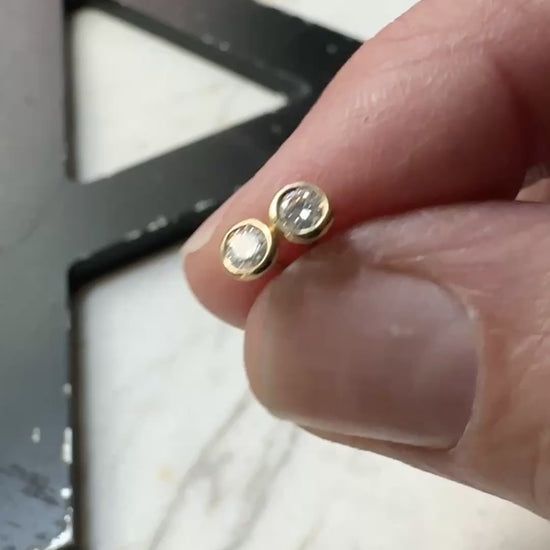 18k yellow gold 3mm Moissanite bezel set stud earrings on a marble background 