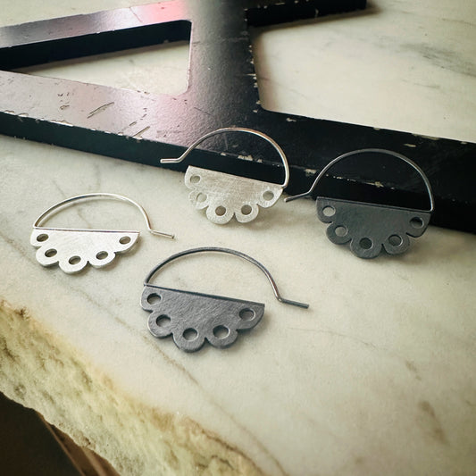 two pair of scalloped earrings with pierced design. One pair bright silver and one pair oxidized silver 