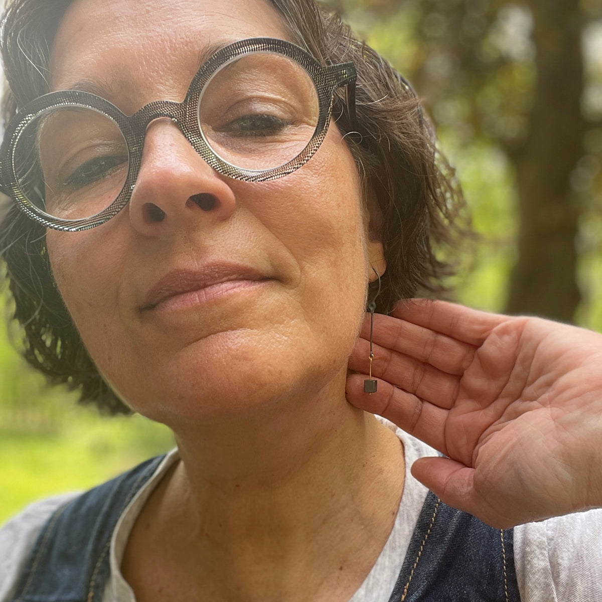 woman wearing glasses and long dangly skinny earrings