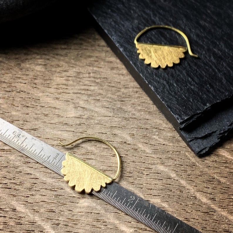 18k yellow gold scalloped edge hoop earrings on a ruler measuring five eights inch in diameter. 