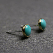 Load image into Gallery viewer, 5mm nevada turquoise stud earrings set in 18k yellow gold shown from side to show sterling silver posts
