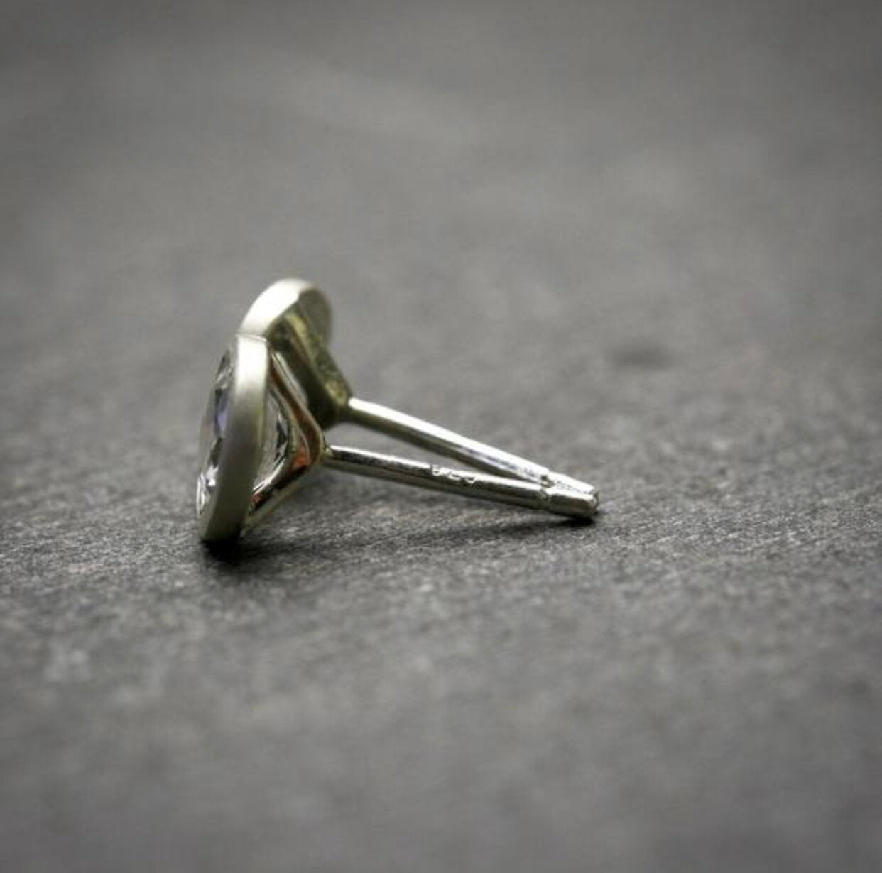 bezel set 5mm white topaz stud earrings in sterling silver shown from the side to show earring posts