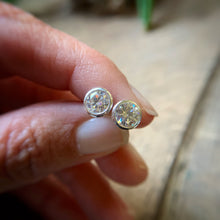 Load image into Gallery viewer, 6mm sterling silver Moissanite stud earrings being held to show scale
