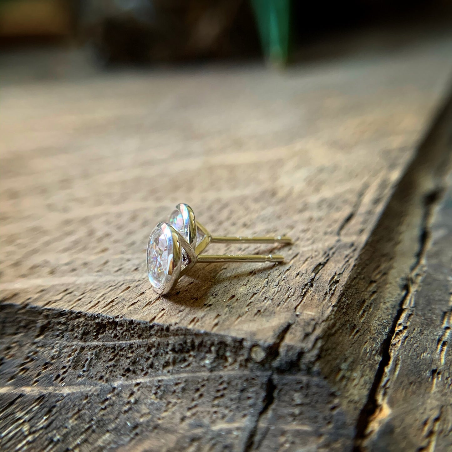 Bezel set Moissanite earrings shown from the side to show the back of the earrings