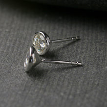 Load image into Gallery viewer, 5mm bezel set Moissanite stud earrings in sterling silver.  Shown from the side to show posts
