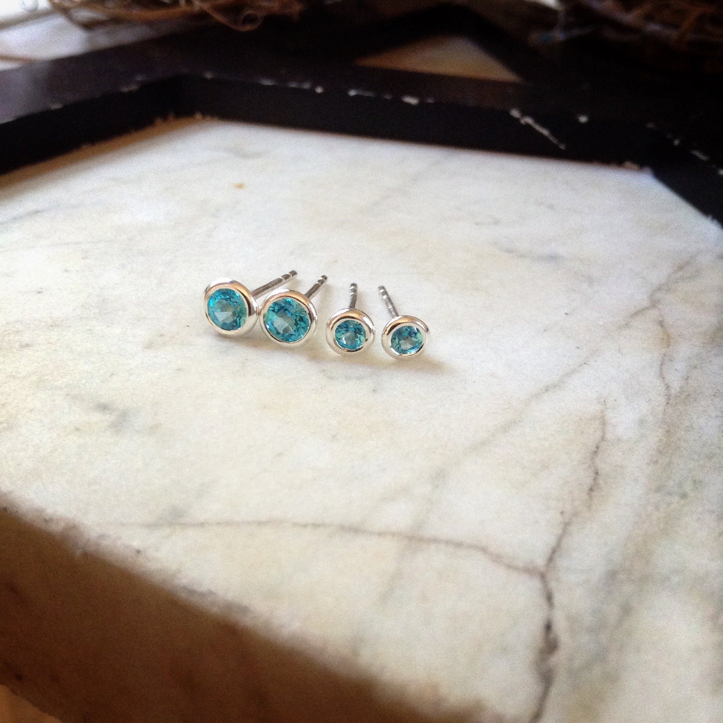 two sizes of bright blue topaz set in sterling silver bezels