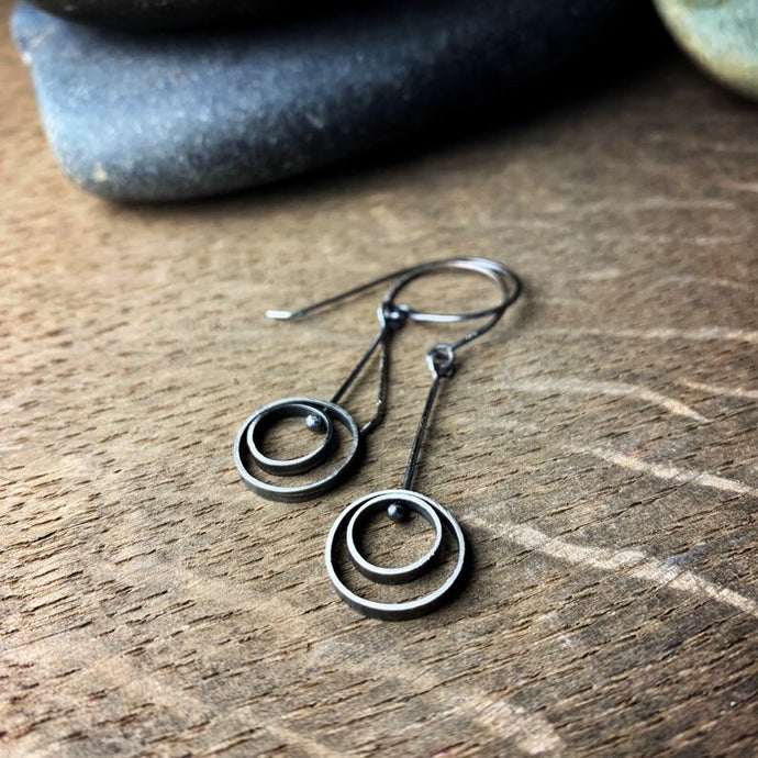 concentric circle hanging earrings with ear wires.  They are oxidized sterling silver