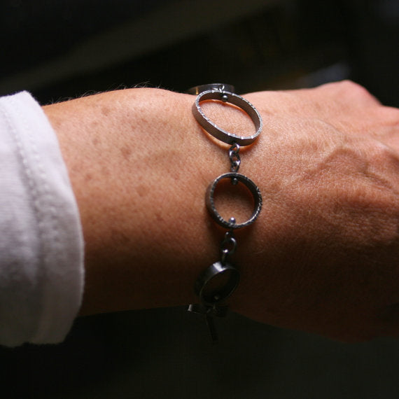 oxidized silver circle link bracelet on a wrist for scale