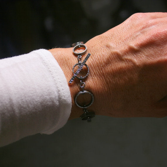 toggle clasp of textured circle link bracket shown on a wrist for scale