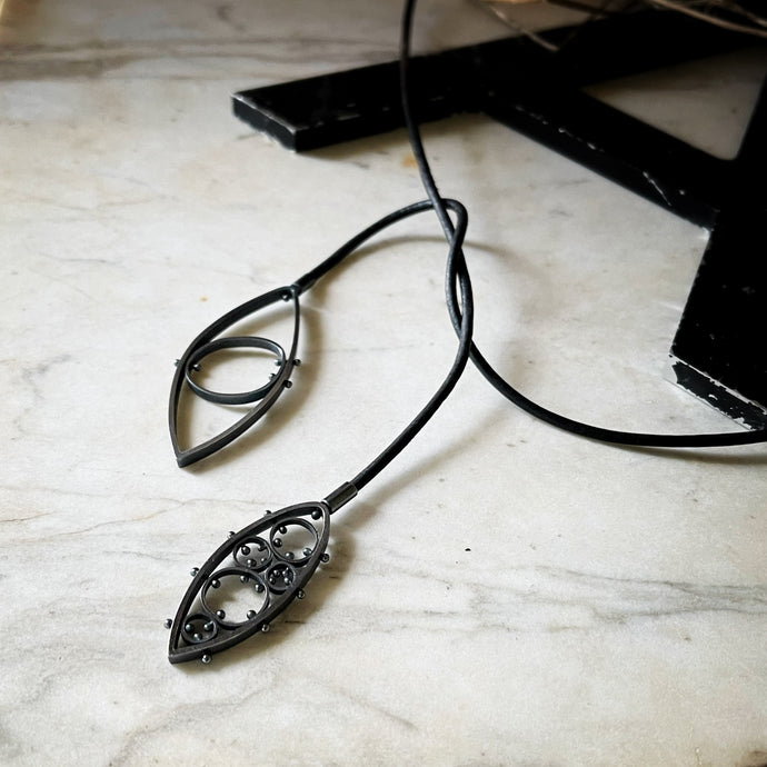 two modern leaf shaped pendants on a leather cord.  This view shows one way to wear this pendant