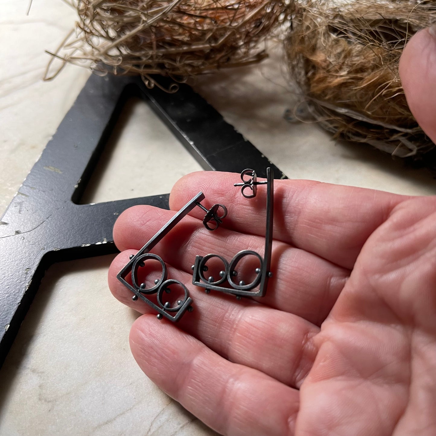 earrings shown on a hand for scale