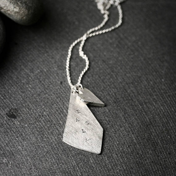 triangular shaped silver pendant with stamped initials and a chunky heart