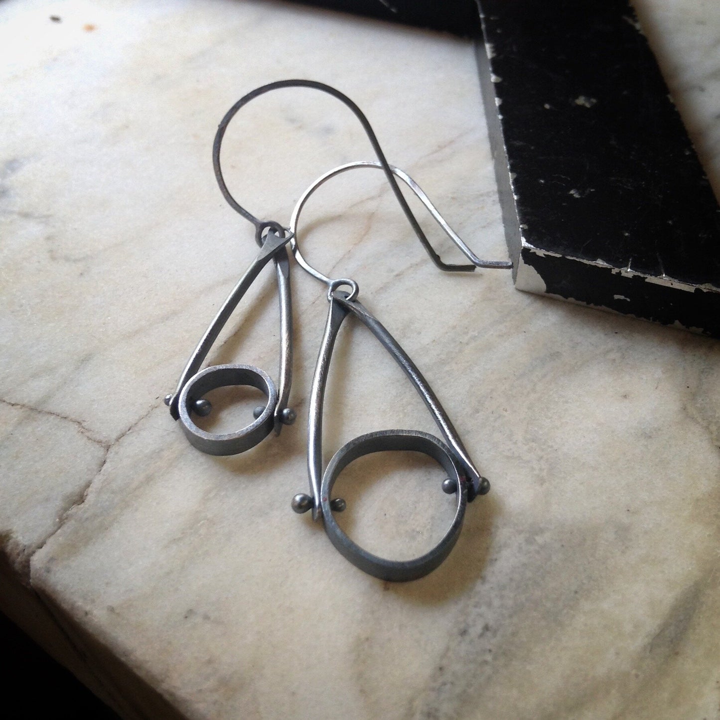 both sizes of earrings in oxidized sterling silver with an industrial look and organic circles