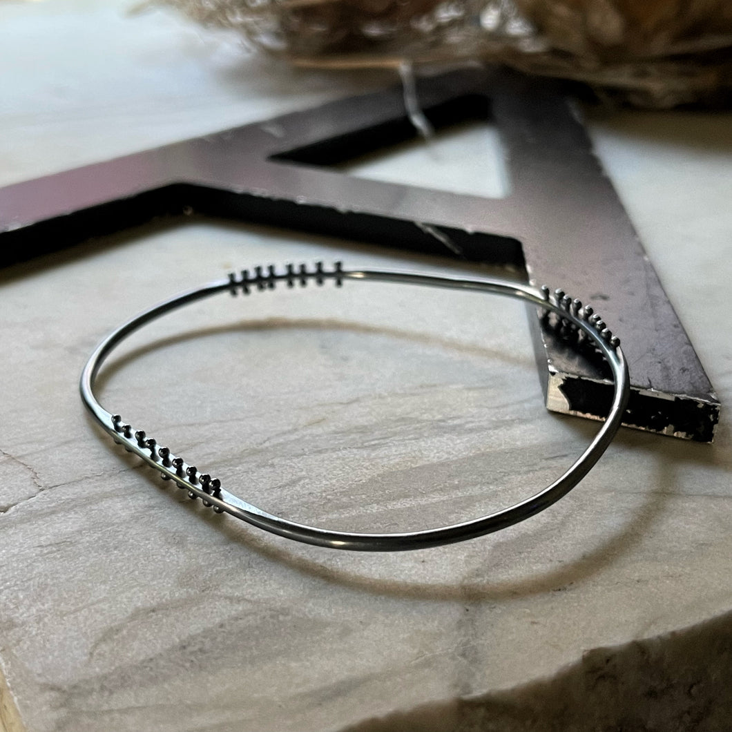 oxidized silver bangle bracelet with three stations of silver pins