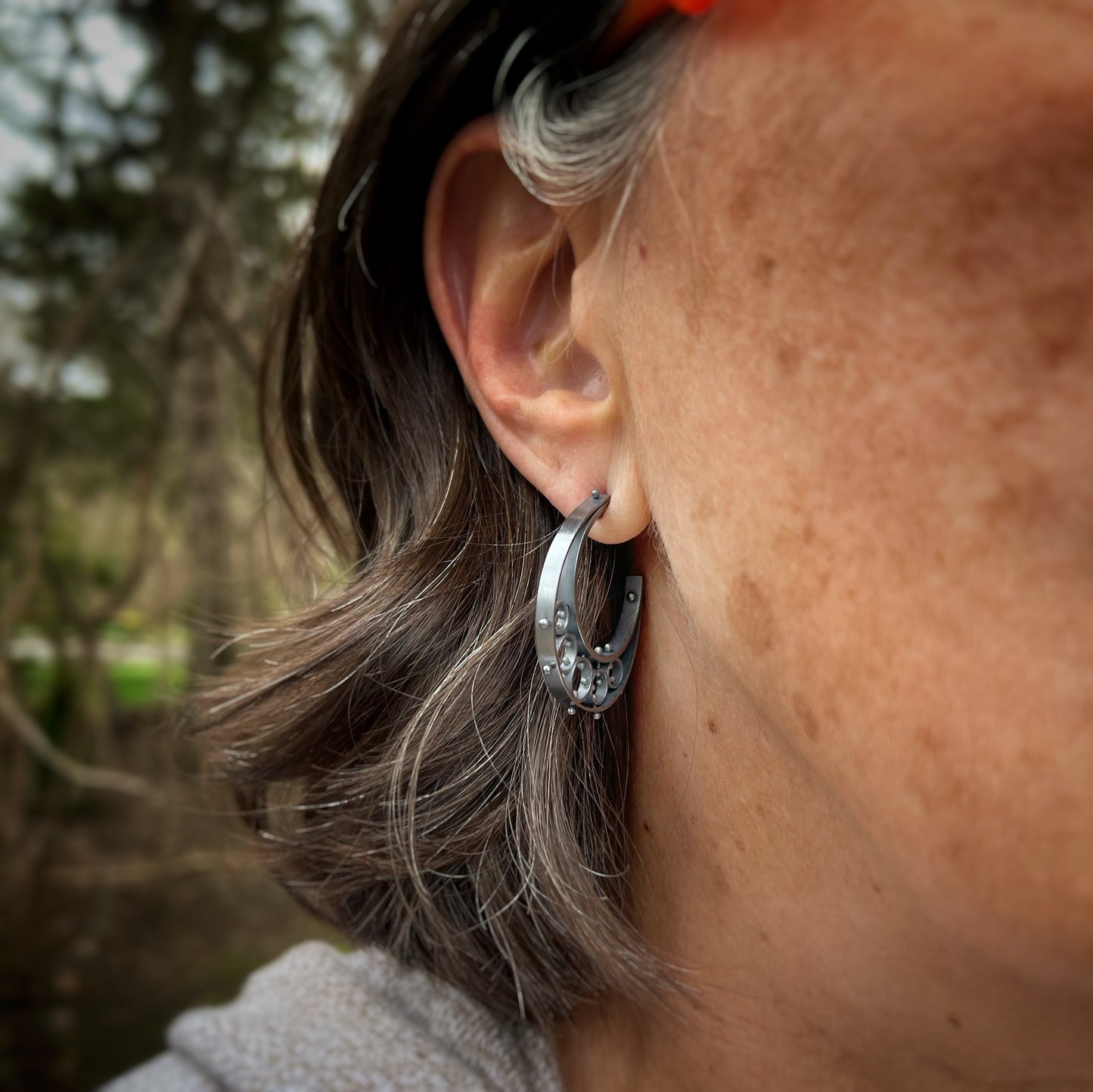 half moon shaped earrings shown on a model