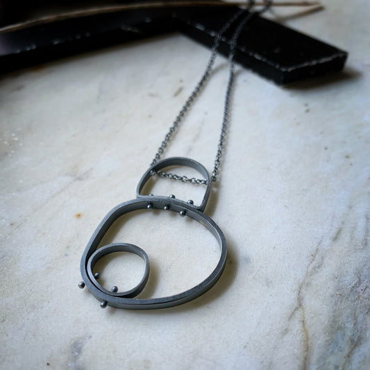 Modern industrial circle in circle darkened silver pendant