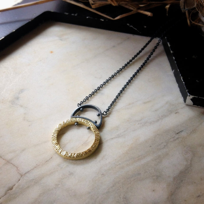 large textured gold circle with half circle sterling silver bail and silver chain pendant